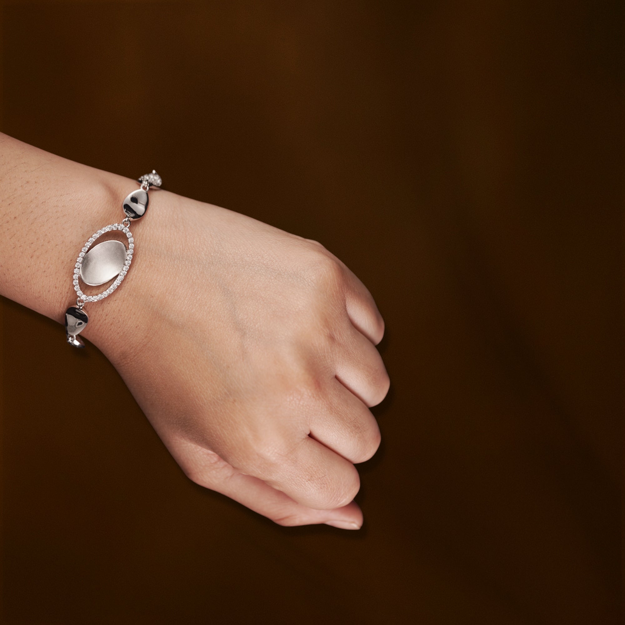 Elegant Silver Bracelet with Textured Ovals and Crystal Accents